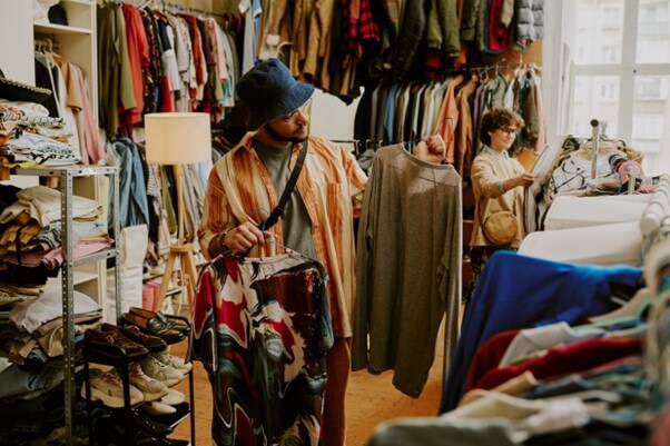 Man shopping clothes in a second hand store.