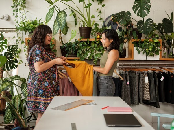 Women in second hand store holding clothes